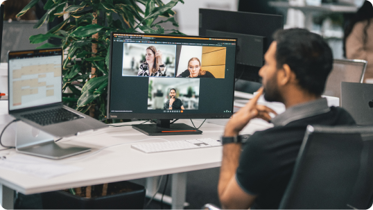 A developer on a video call with remote teammates at his desk